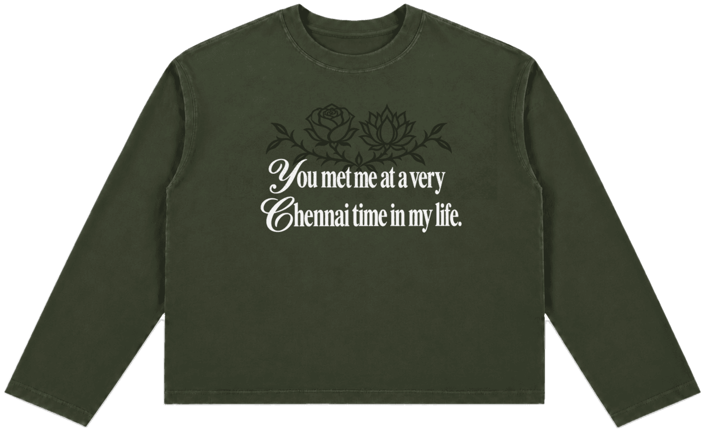 The Chennai Time Sweatshirt — Oversized cropped long-sleeve sweatshirt in deep green with a rose and lotus graphic and the line "You met me at a very Chennai time in my life."